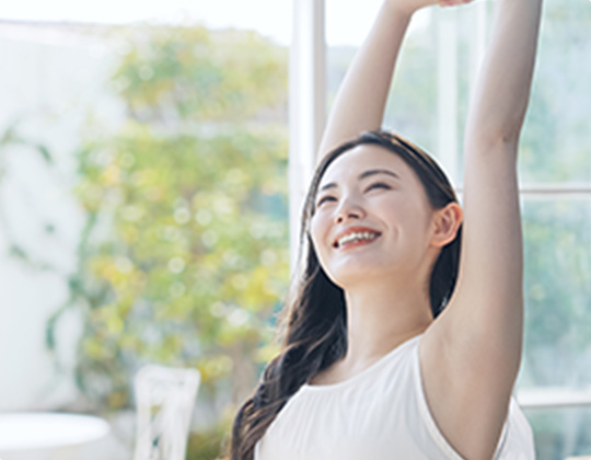 腕を上げ伸びをする女性